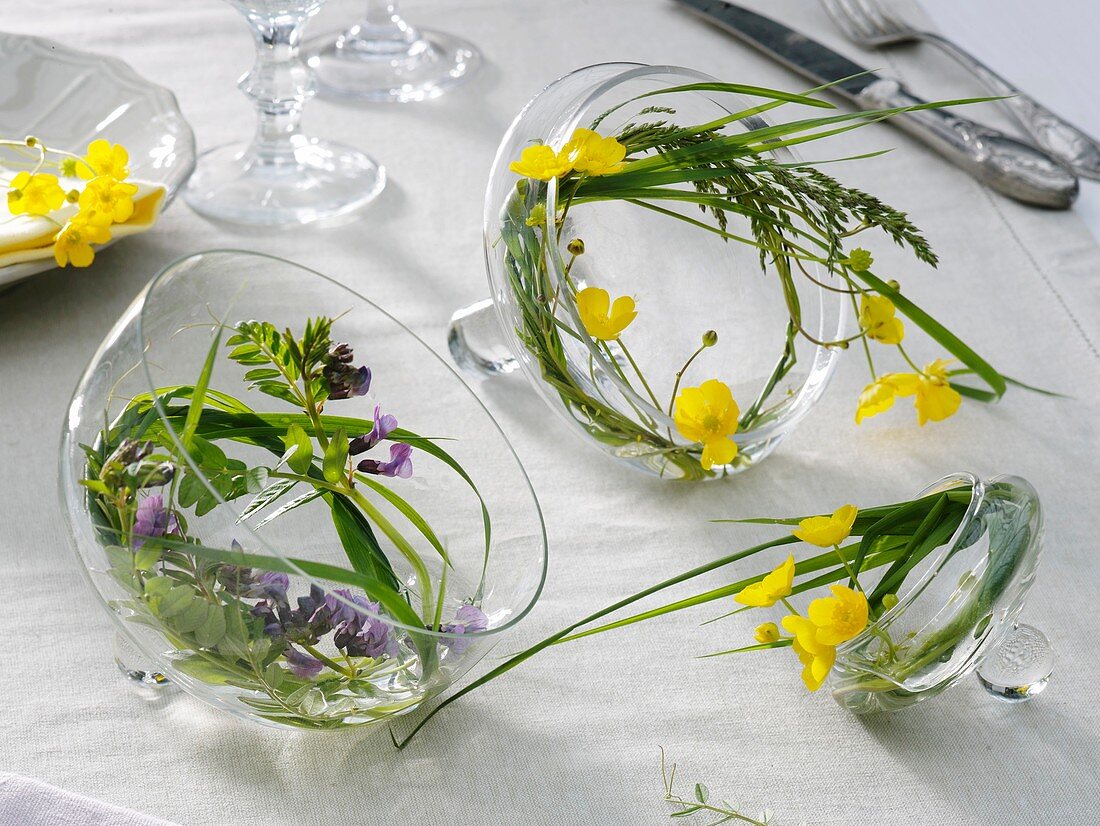 Small wreaths of grass and flowers in glass lids