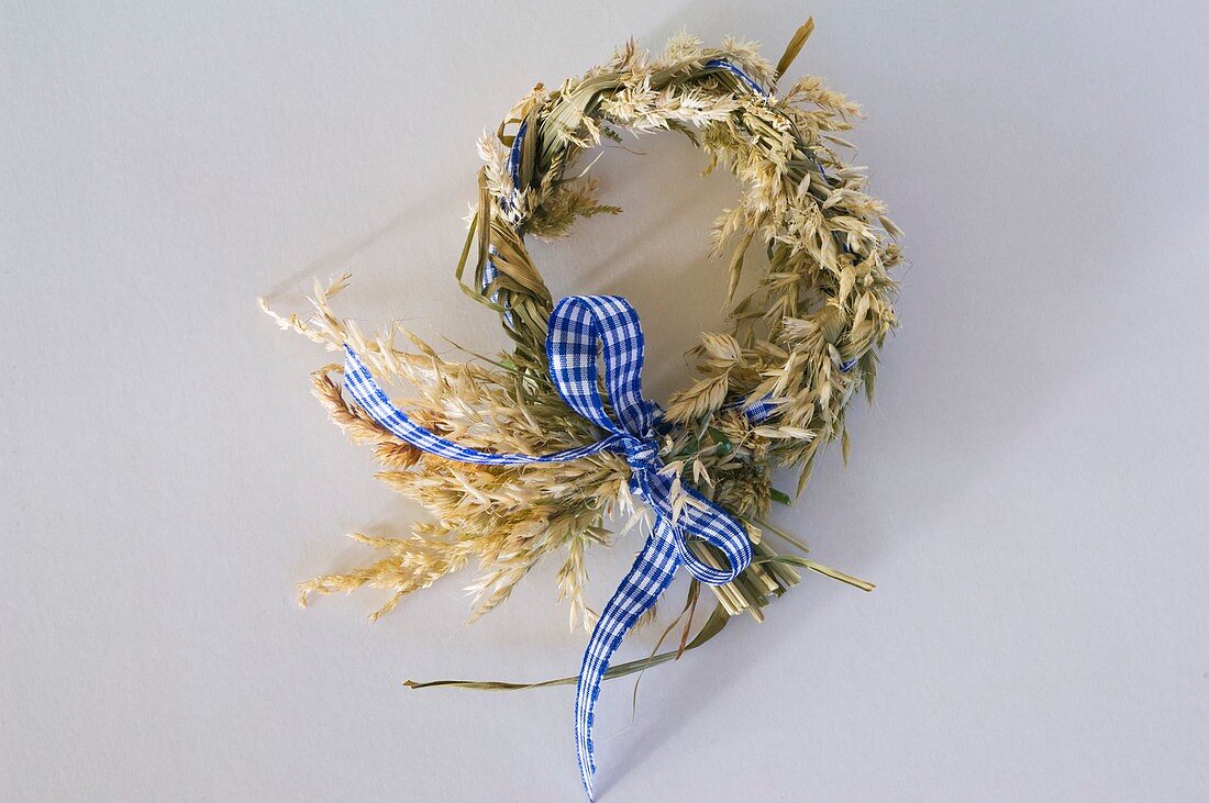 Wreath of flowering grasses with blue and white ribbon