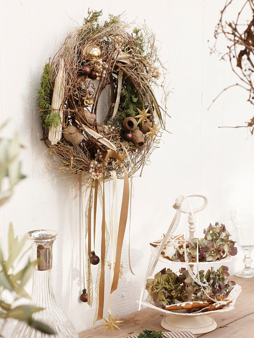 Wall wreath of twigs, dried fruit and Christmas tree ornaments
