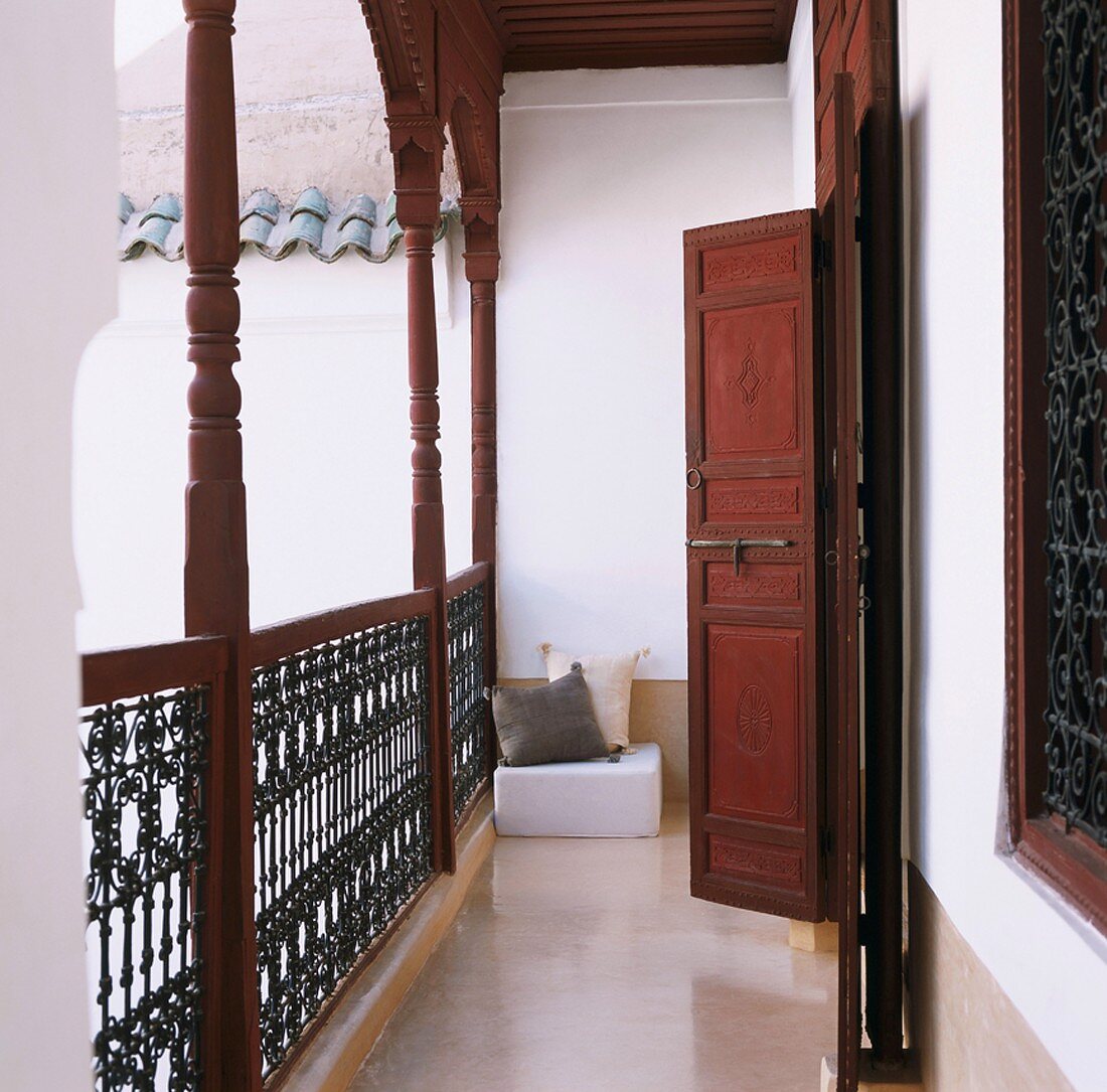 Erschliessungsbalkon mit Geländer und offenen Holztüren im orientalischen Stil