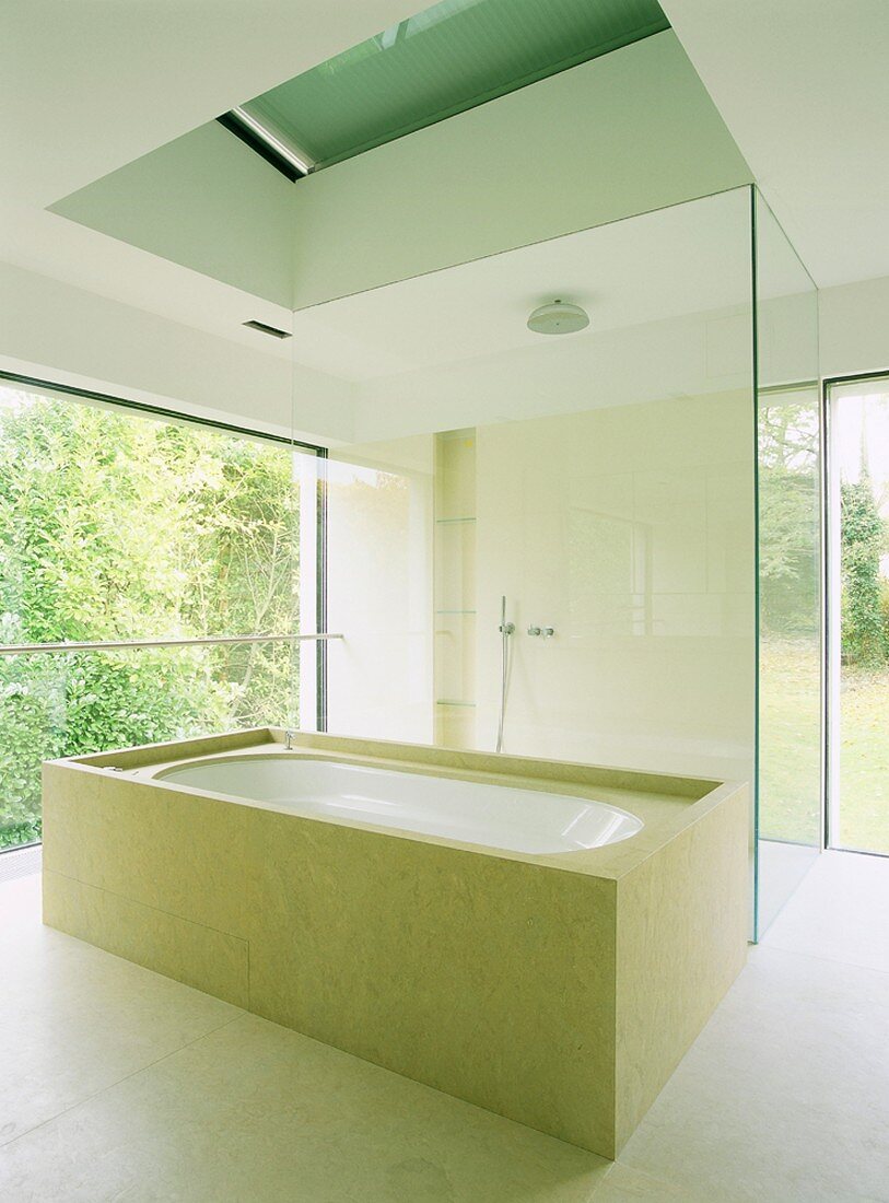 Aufgeglastes Designer-Bad im minimalistischen Stil mit umbauter Wanne und begehbarer Dusche
