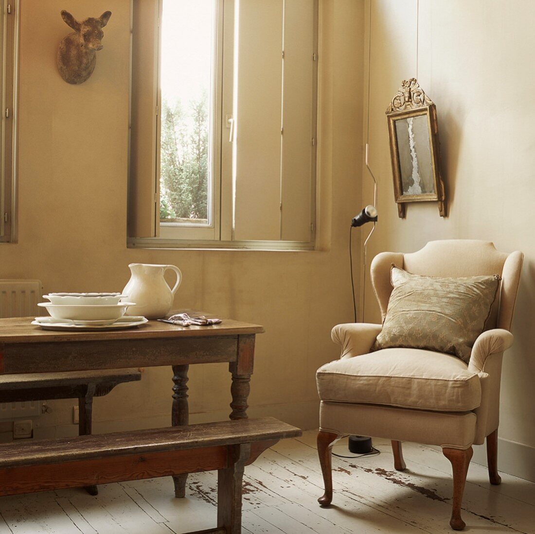 Second-hand character - old-fashioned armchair in rustic dining area with interior shutters on window