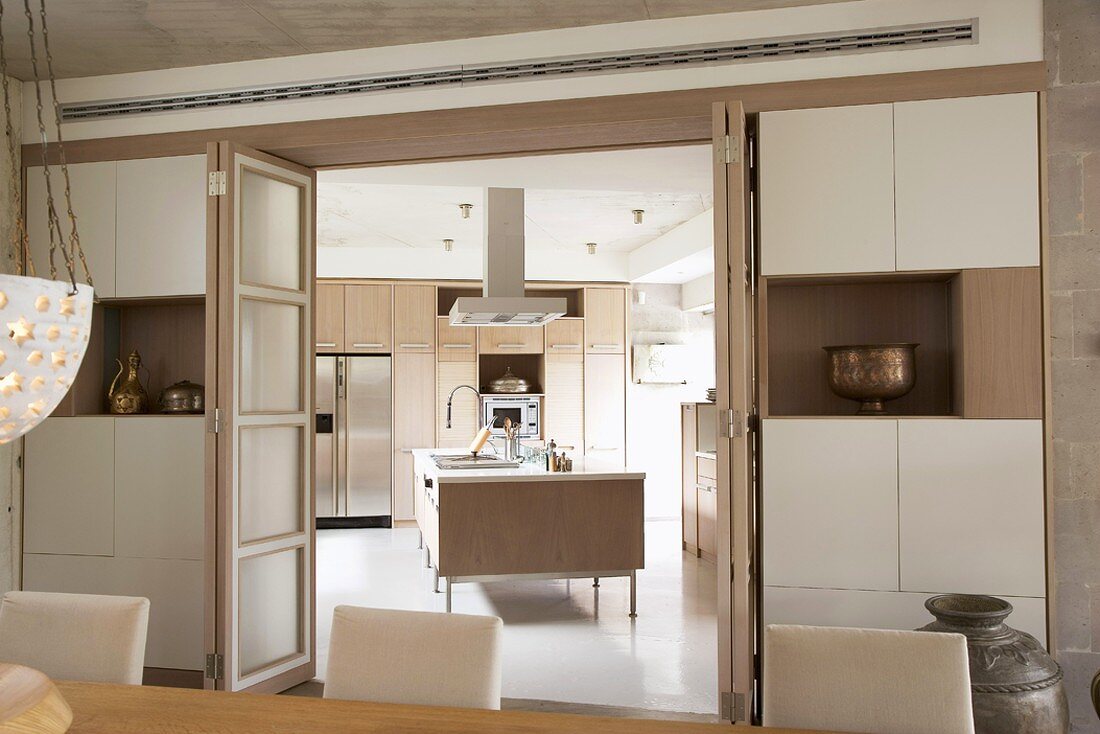 Blick vom Esszimmer in moderne Küche mit Küchenblock