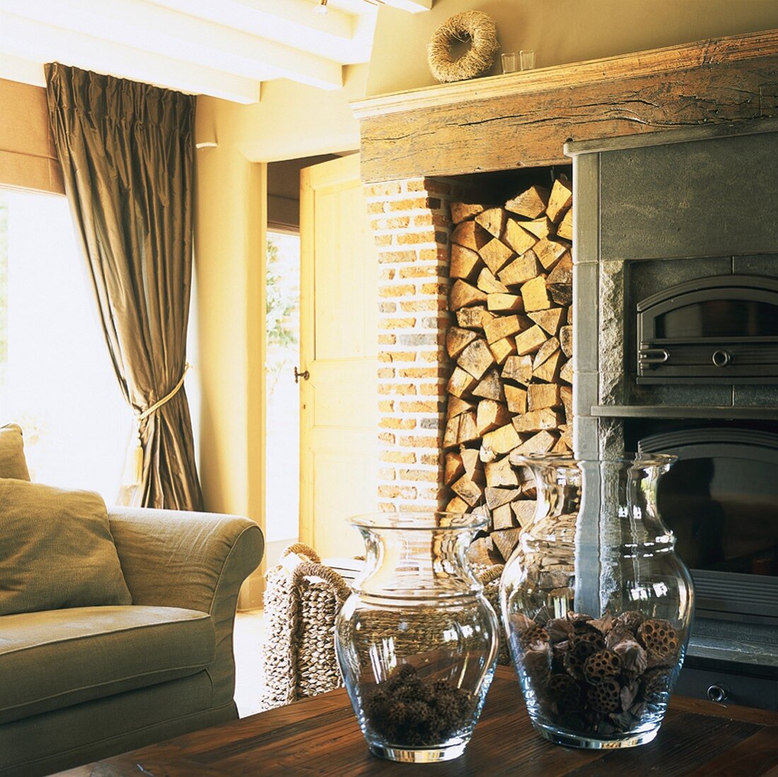 Rustic living room with stacked firewood and brick wall