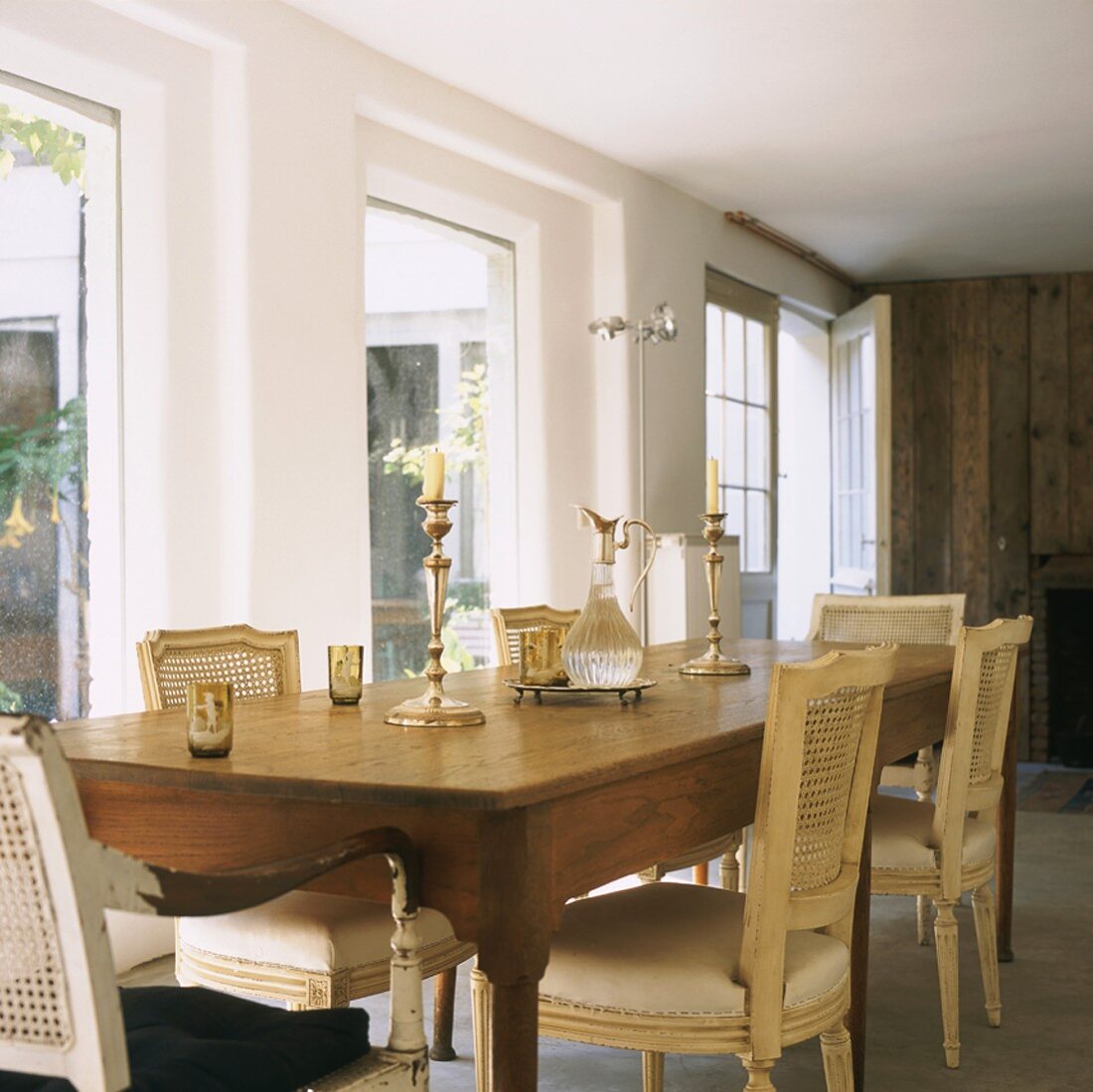 Long dining table and upholstered chairs with cane backrests