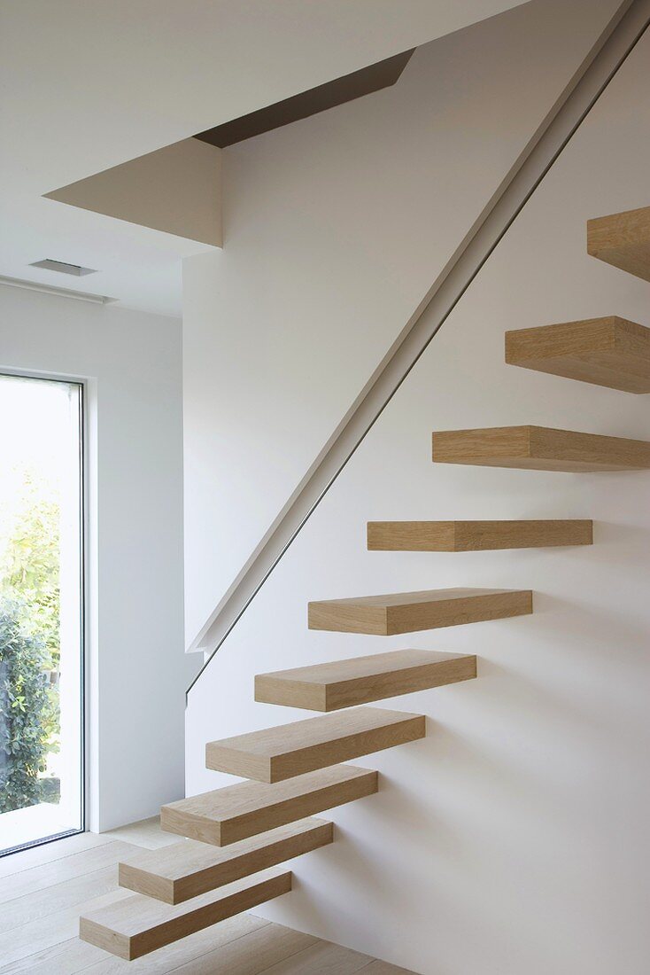 Cantilever wooden stairs with handrail recessed in wall