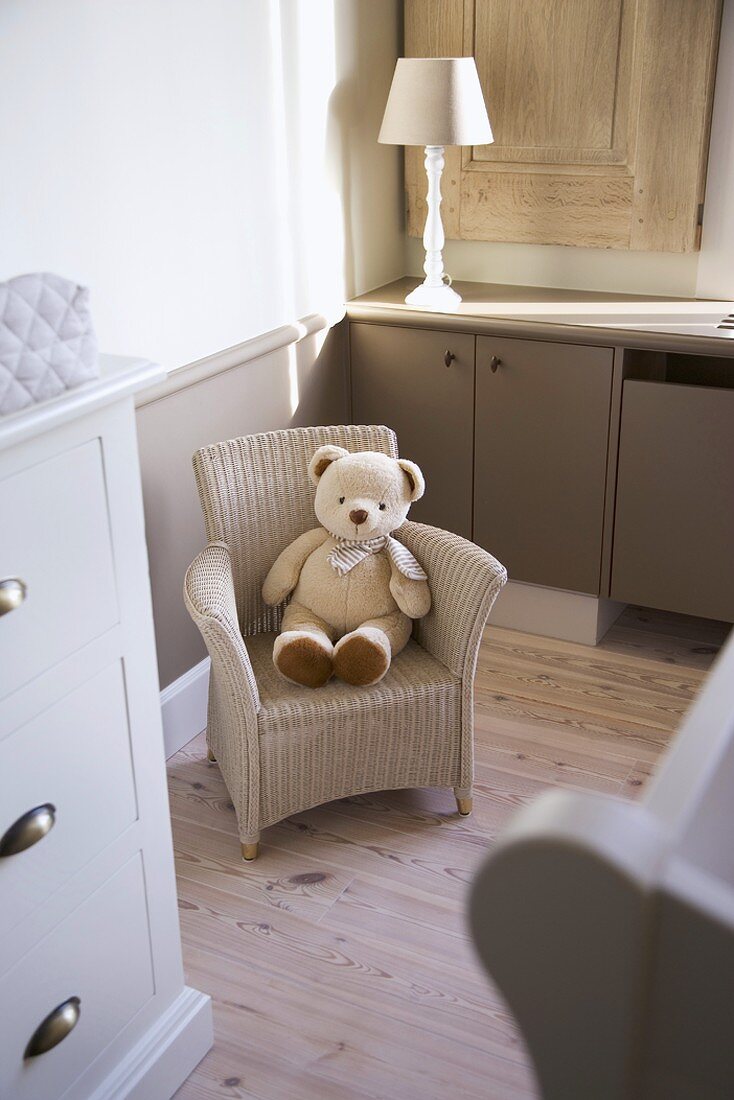 Teddy bear sitting on child's wicker chair