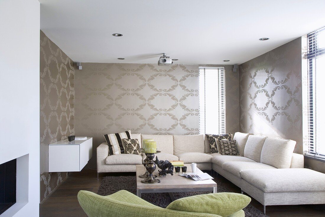 Interior with pattern of ellipses on silver-grey wallpaper, white corner couch, coffee table and sideboard