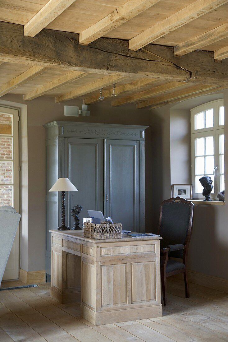 Rustic interior with large wooden desk and blue, vintage-style wooden cupboard