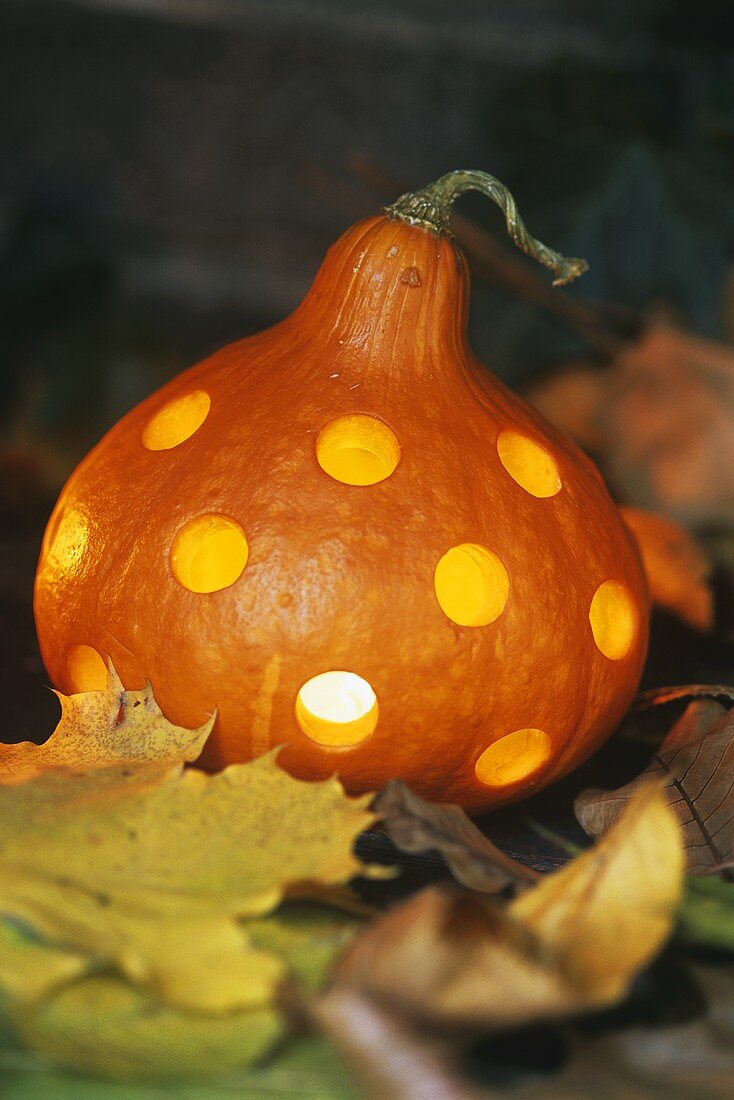 Hollowed-out pumkin with holes and light inside