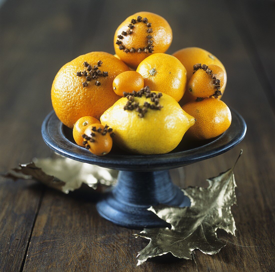 Citrus fruit studded with cloves in a bowl
