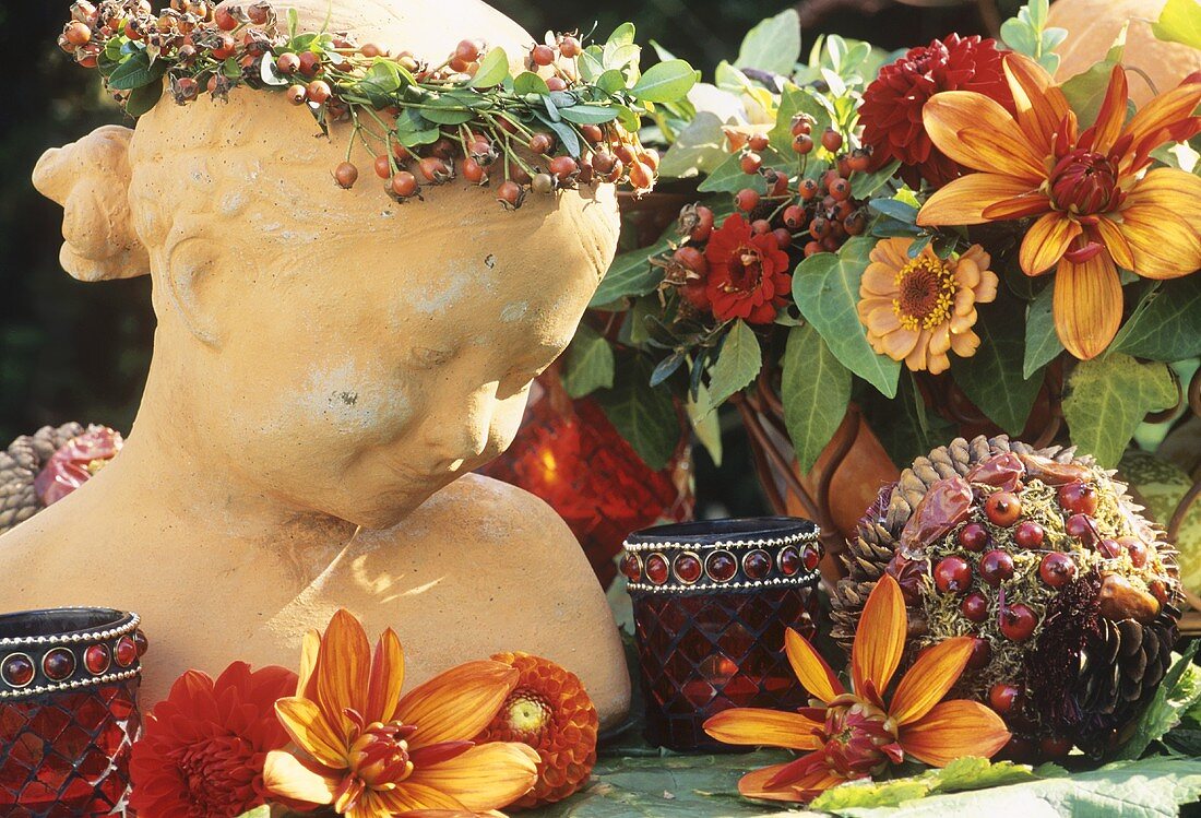 Büste mit Hagebuttenkranz und Blumendeko in warmen Farben