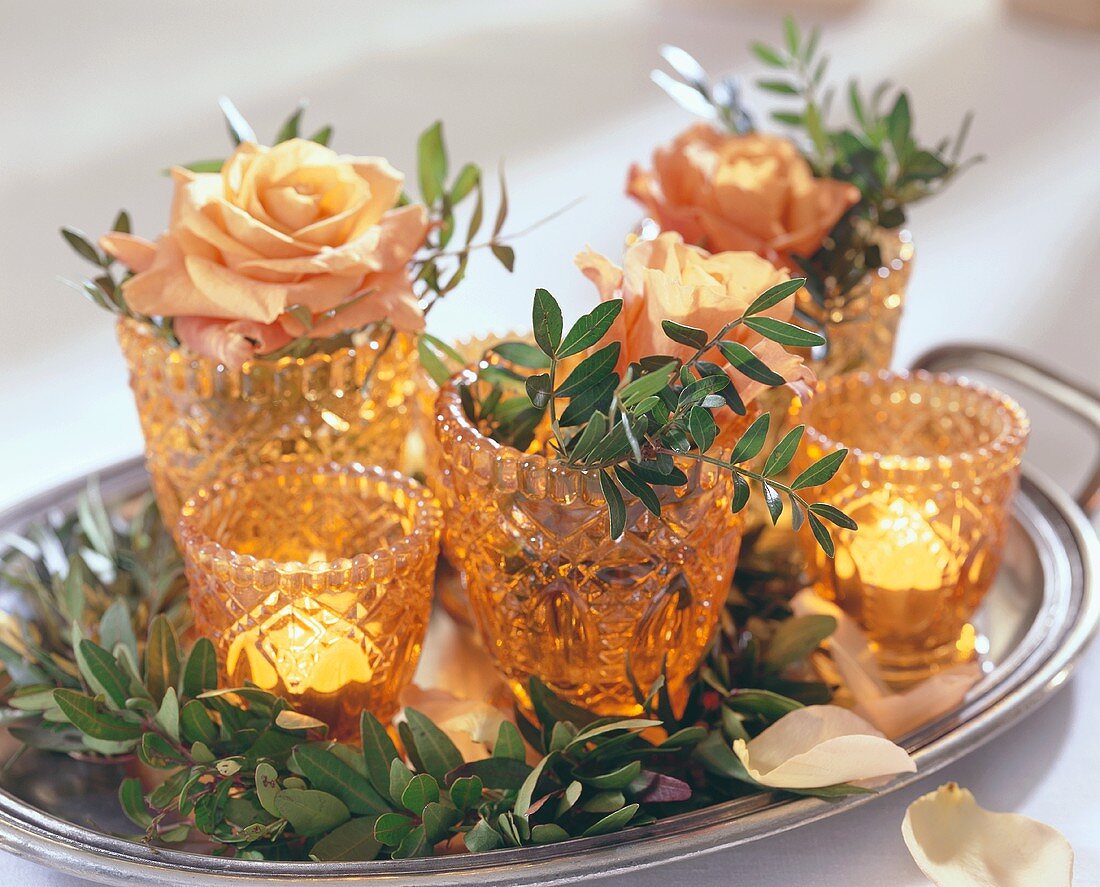 Small vases with roses, pistachio foliage & candles