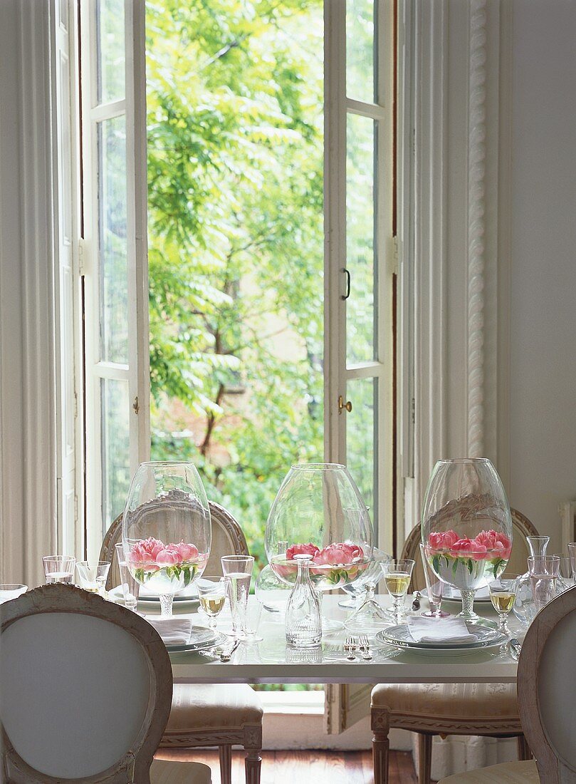 Laid table with wine and flowers floating in glasses