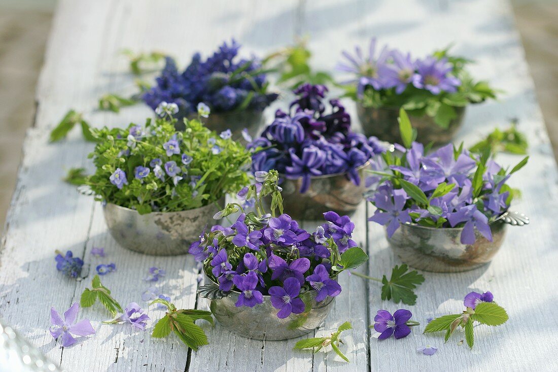 Silver bowls filled with various blue & purple flowers