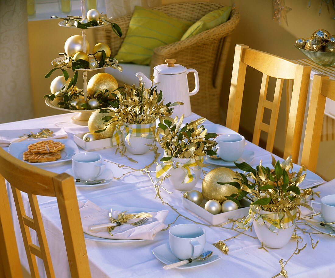 Table laid for coffee with arrangements of mistletoe