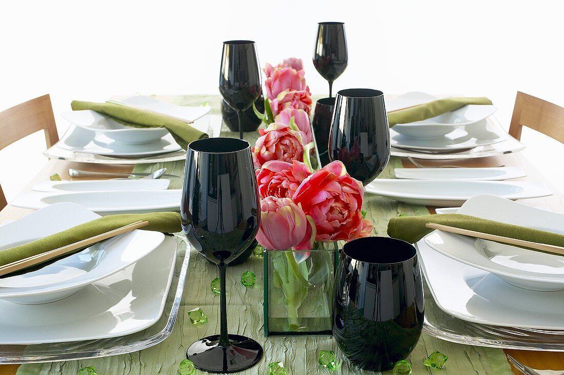 Gedeckter Tisch mit schwarzen Gläsern und Essstäbchen