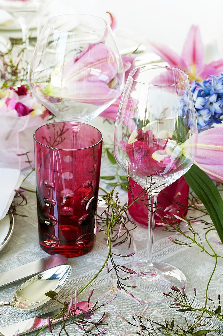 Gläser auf festlich gedecktem Tisch mit Blumendeko