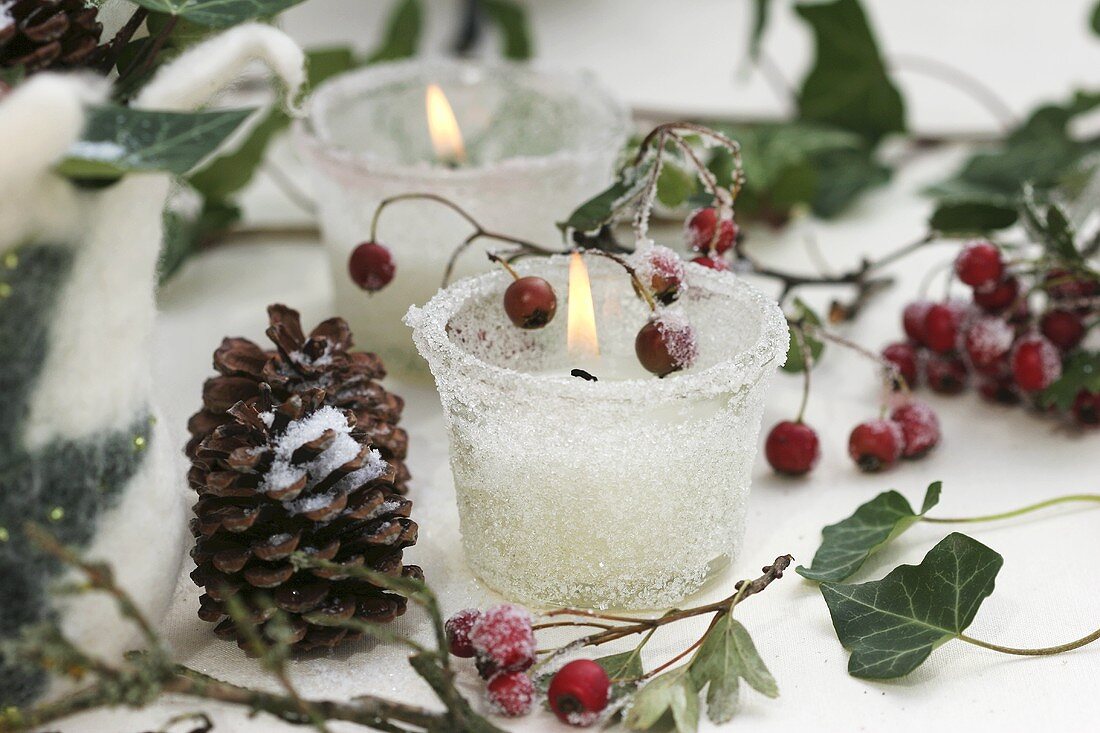 Frosted glasses with candles, cones and haws