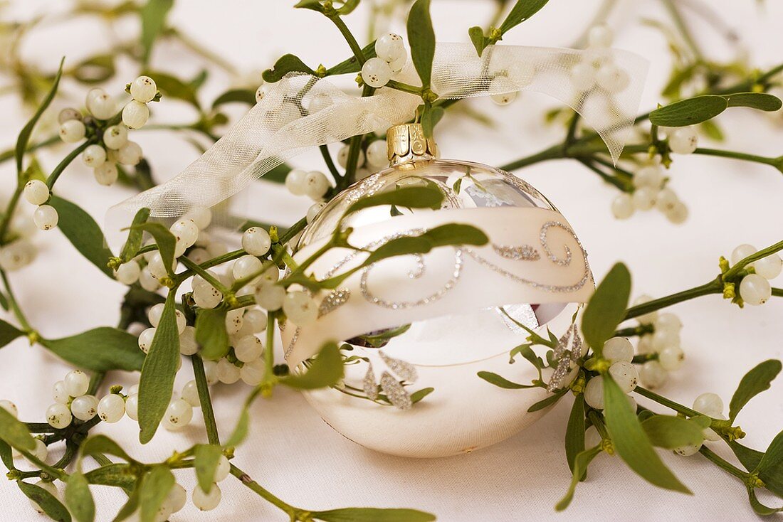 A Christmas bauble amongst mistletoe