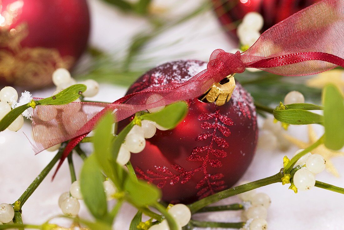 Rote Weihnachtskugeln zwischen Mistelzweigen