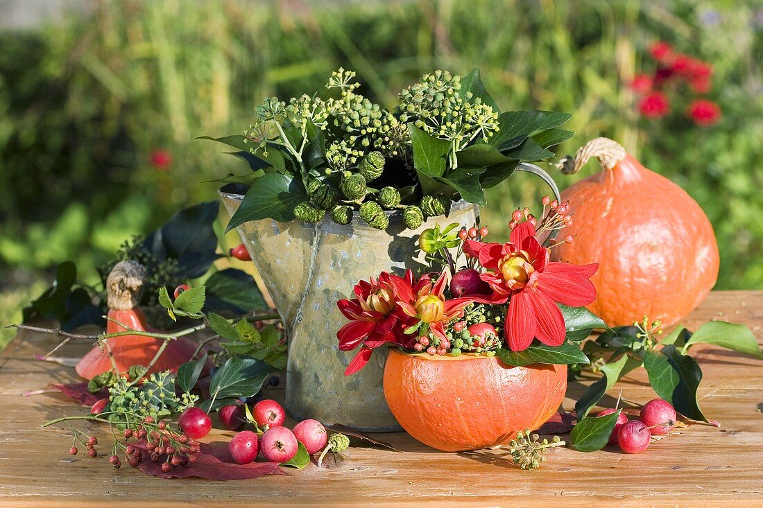 Herbstliche Deko mit Efeu, Kürbis, Dahlien und Zieräpfel