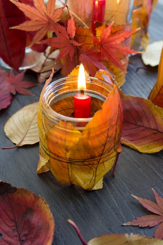 Windlicht mit Herbstlaub dekoriert