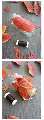Decorating a candle lantern with autumn leaves