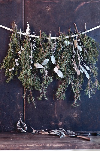 Weihnachtliche Girlande aus Nadelzweigen & silberfarbenen Blättern