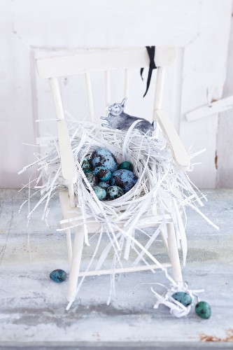 An Easter nest made of strips filled with blue and green eggs