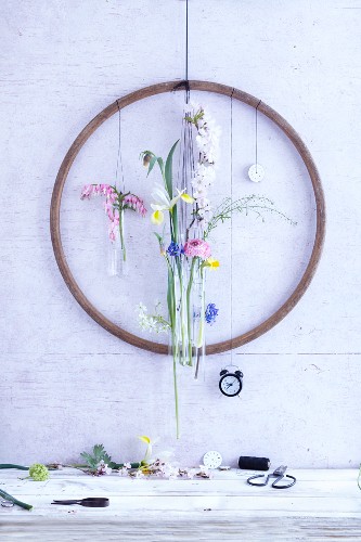 An old wooden hula hoop on a wall decorated with spring flowers