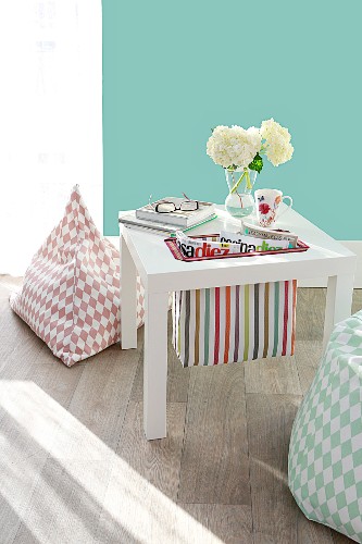 Side table with hand-sewn magazine pouch made from striped fabric