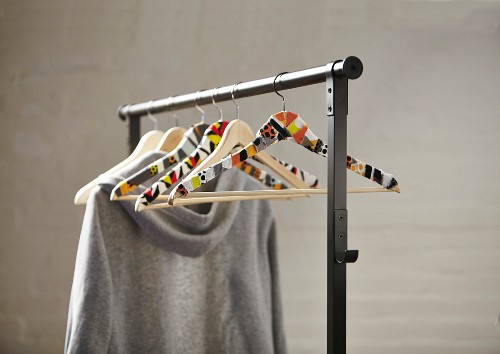 Coat hangers covered in fabric remnants on clothes rail