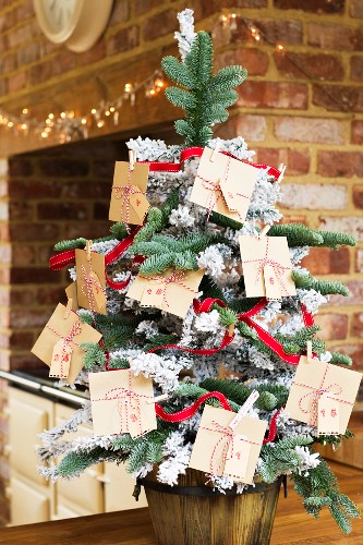 Christmas tree decorated with DIY Advent calender made from envelopes tied with ribbons
