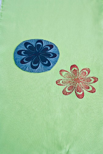 Linoleum template with floral motif and coloured print on fabric