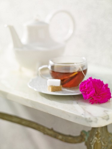 Tasse Tee mit einem Teeanhänger aus Papier in Form einer Nelke