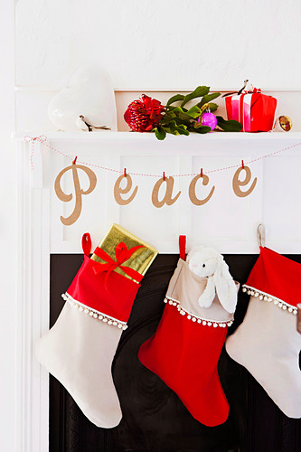 Christmas stockings and a garland of letters by the fireplace