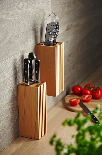 Wooden organiser and knife block on wall panel in kitchen