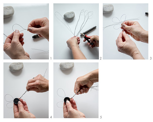 Hands bending wire to make flower with button centre