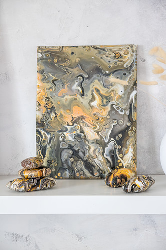 Canvas and pebbles painted with marble pour technique in natural colours