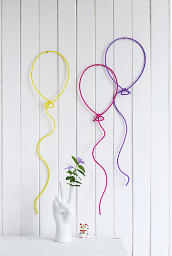 Wall decorations shaped like balloons made from wire and knitted tubes