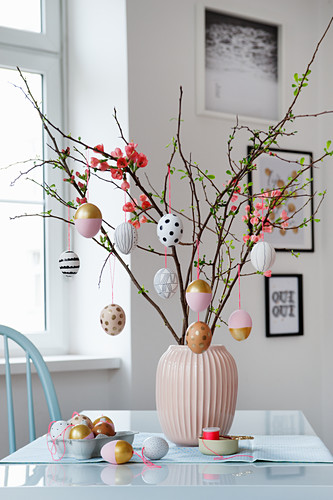 Handmade Easter eggs hung from branches in vase
