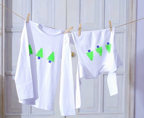 Shirts mit Weihnachtsbaum-Motiv hängen an der Wäscheleine