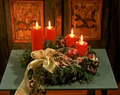 Adventsgesteck mit brennenden Kerzen