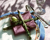 Place decoration of flower stalks & lavender on purple napkin