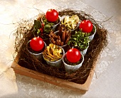 Christmas arrangement in a terracotta bowl with four candles