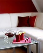 Two beakers of fruit tea on a glass table