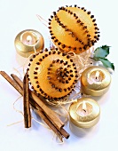 Oranges studded with cloves, cinnamon sticks and candles