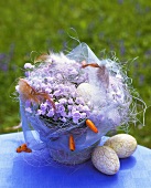 Easter arrangement of bluebells, feathers and eggs