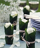 Roses in glasses wrapped in leaves